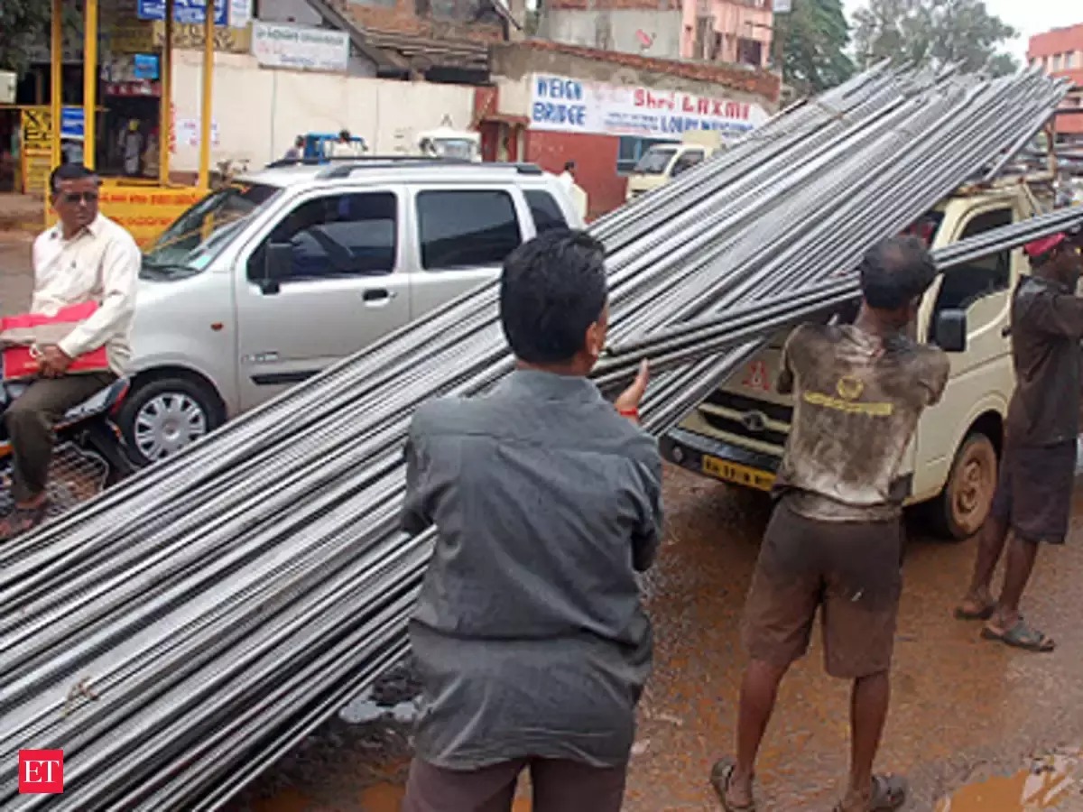 Workers unloading steel rebar coils at Azamgarh site